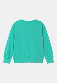 Sudadera turquesa de corte relajado, con mangas largas y puños fruncidos. Textura suave y escote redondo; detalles mínimos.