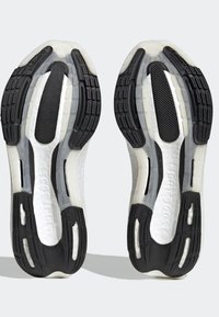 Semelles en caoutchouc noir et blanc de chaussures de sport avec motif de bande de roulement texturé et marquage visible « Continental » sur un fond clair.