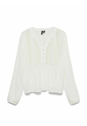Blouse blanche à manches longues avec broderie en dentelle festonnée sur la poitrine, trois boutons recouverts de tissu, col rond et poignets élastiques.