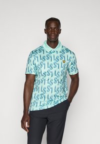 Polo à manches courtes en turquoise clair avec un motif répétitif de lettres. Dispose d'un col et d'un petit logo jaune sur la poitrine.
