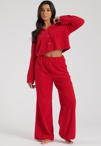 Rød, fyldig loungewear sæt med en cropped knapbluse og løstsiddende bukser med elastisk talje og blød tekstur.
