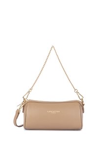 Sac à main cylindrique en cuir beige avec une bandoulière en chaîne dorée et un logo doré "Lancaster Paris" sur le devant.