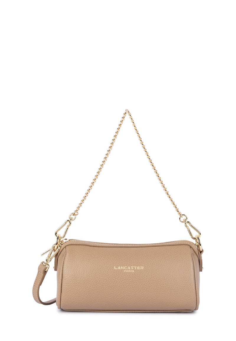 Sac à main cylindrique en cuir beige avec une bandoulière en chaîne dorée et un logo doré "Lancaster Paris" sur le devant.