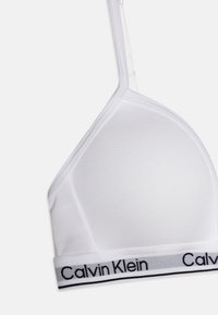Bralette bianco a triangolo realizzato in tessuto morbido, con una fascia nera con logo Calvin Klein e spalline regolabili per una vestibilità personalizzata.