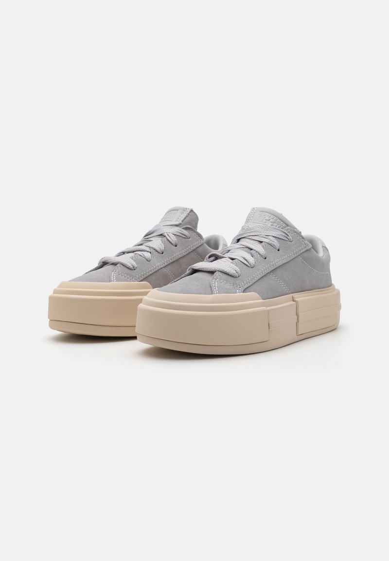 Szare zamszowe sneakersy z grubą kremową gumową podeszwą, teksturowanymi akcentami i płaskimi sznurówkami. Posiadają naszywkę z logo na języku.
