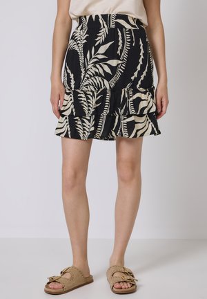 Jupe à tiers noire et crème avec un motif de fougère, dotée d'une taille élastique et d'un design fluide, fabriquée à partir d'un tissu léger.