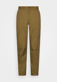 Khaki kalhoty vyrobené z odolné látky, s rovnými nohavicemi, zipem na zapínání, knoflíkovým uzávěrem a malým logem na spodní části nohy.