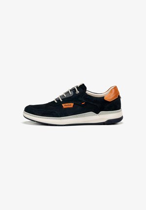 Zapatilla baja negra y marrón con suela blanca, cordones grises y parche con el logo naranja de Fluchos en el lateral.