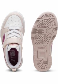 Sneakers Puma con un upper sintetico rosa chiaro, dettagli bianchi, cinturino in velcro e una suola in gomma testurizzata con motivi circolari.