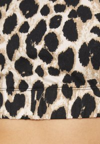 Braun und schwarzes Leopardenmuster-Stoff mit weicher Textur und Stretch. Verfügt über eine Saumnaht am unteren Rand. Hintergrund ist hell gefärbt.