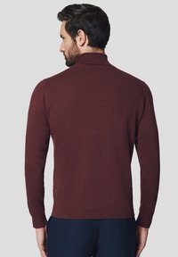 Bordowy sweter z dzianiny z wysokim kołnierzem, ściągaczami na mankietach i u dołu, charakteryzujący się gładką teksturą i dopasowaną sylwetką.