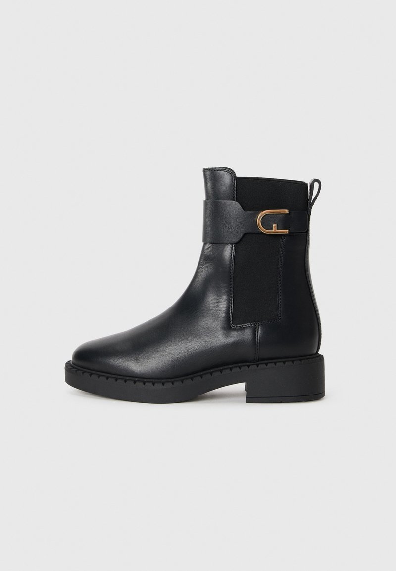 Bottine en cuir noir avec panneaux élastiques sur les côtés, talon carré et accent en métal doré. Texture lisse et design à bout arrondi.