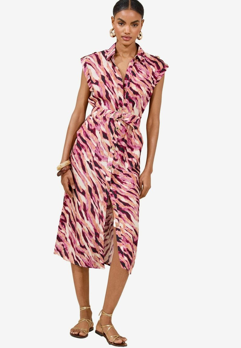 Vestido de botones en un vibrante estampado animal en rosa y crema. Cuenta con una cintura ceñida con cinturón, mangas cortas y una abertura alta en el muslo.