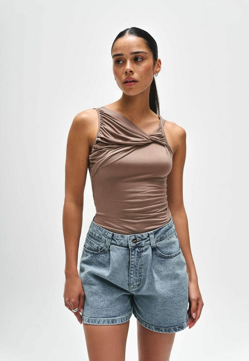 Bruine aansluitende tanktop met geplooide details bij de halslijn, gecombineerd met lichtgewassen denim shorts met een hoge taille en een losse pasvorm.