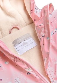 Chubasquero rosa para niños con estampados de unicornios y arcoíris, forro de felpa beige y una etiqueta que muestra la talla 6 y una altura de 116 cm.