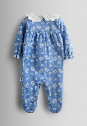 Blå blomstrende jumpsuit med lange ærmer, hvid blondekrave og elastiske manchetter. Har små hvide blomstermønstre på blødt stof.