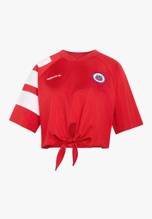 Maglietta sportiva rossa Adidas a girovita con maniche corte, strisce bianche sulla manica sinistra, logo della squadra del Cile sul petto e nodo frontale.