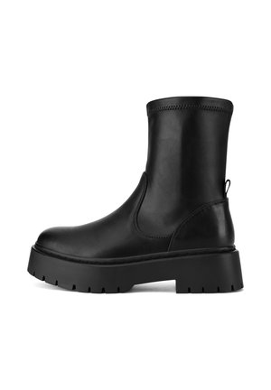 Black ankle boot made of smooth leather. Features a rounded toe, elastic side panels, and a chunky treaded sole for traction.