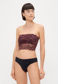 Bordová, čipková top bez ramienok s kvetinovými vzormi, spojená s čiernymi bikiny nohavicami. Top má vlnitý lem a priesvitné detaily.