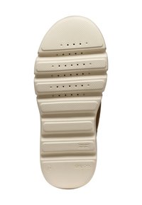 Suela de un zapato beige con agarre texturizado, perforaciones para transpirabilidad y marcas de tamaño 31, patente italiana y marca Geox.