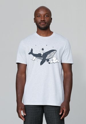 Grijze katoenen t-shirt met een geprinte afbeelding van een persoon in een ruimtepak die op een walvis rijdt, omringd door sterren en wolken. Korte mouwen.