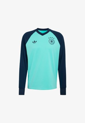 Vaaleansininen pitkähihainen urheilupaita, jossa tummansiniset hihat, Adidas-logo oikeassa rinnassa, Saksan jalkapalloembleemi neljällä tähdellä vasemmassa rinnassa.