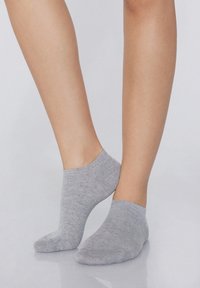 Světlé šedé kotníkové ponožky vyrobené z měkké, texturované tkaniny, s nízkým střihem a bezšvovou špičkou.
