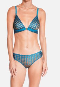 Bralette en dentelle bleue-vert et bikini assorti, avec des bords festonnés et des motifs circulaires sur un matériau transparent. Bretelles réglables avec fermoir métallique.