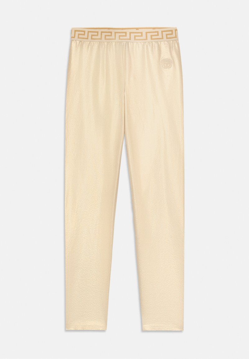 Beige színű, fényes leggings, görög kulcs mintázattal az elasztikus derékpánton. Simább, rugalmas anyagból készült, testhezálló, karcsú dizájn.