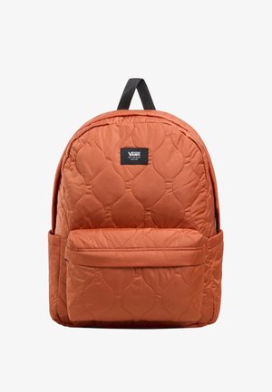 Zaino arancione trapuntato con una patch nera, dotato di tasca anteriore, design imbottito e maniglia superiore per il trasporto. Texture liscia e forma arrotondata.