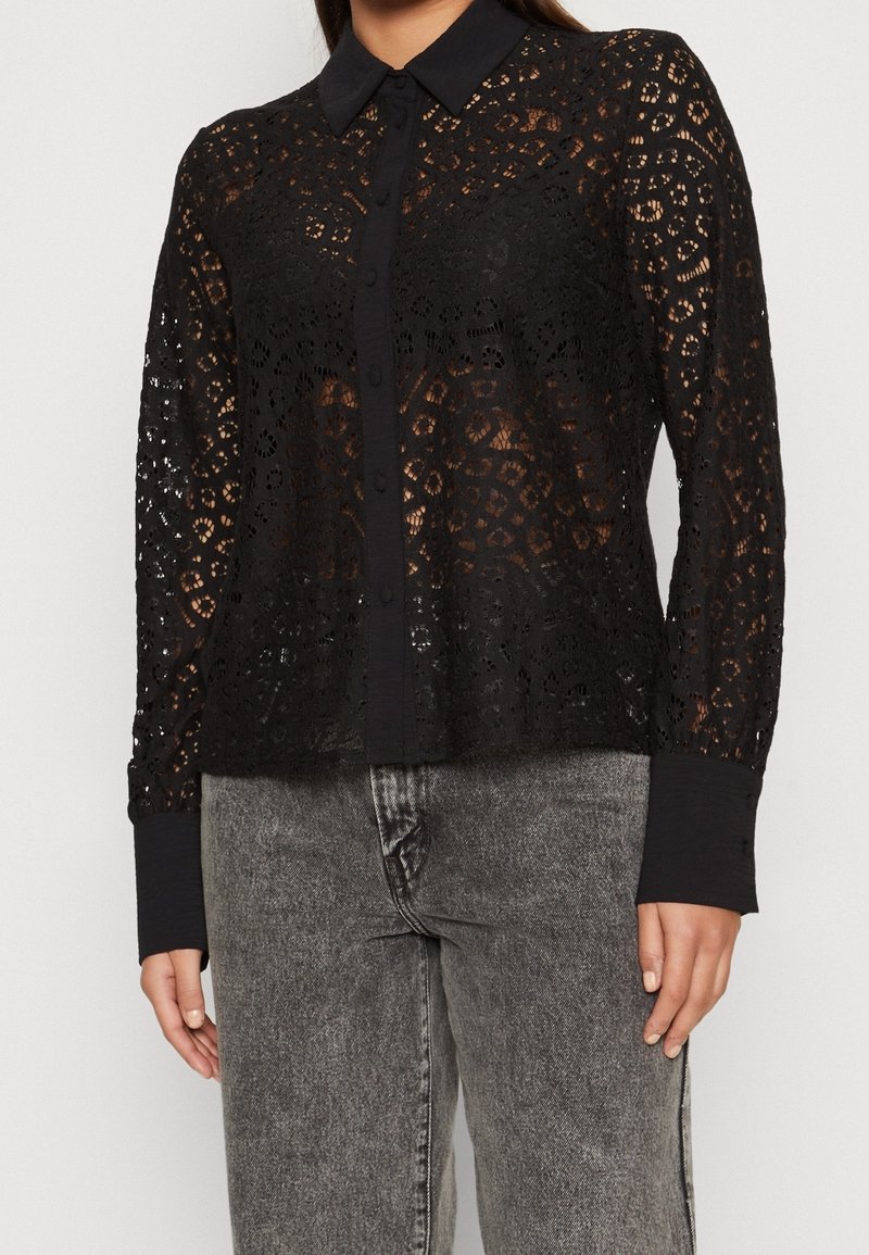 Black lace button-up shirt featuring a sheer design, intricate patterns, a classic collar, and long sleeves with solid cuffs.