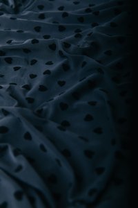 Caurspīdīga tumši zila auduma ar nelielu melnu sirsniņu rakstu, ar mīkstu tekstūru un viegli plūstošu izskatu.