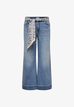 Lyseblå vidbente jeans med frontlommer og et bundet hvitt skjerfbelte med blå paisleymønster.