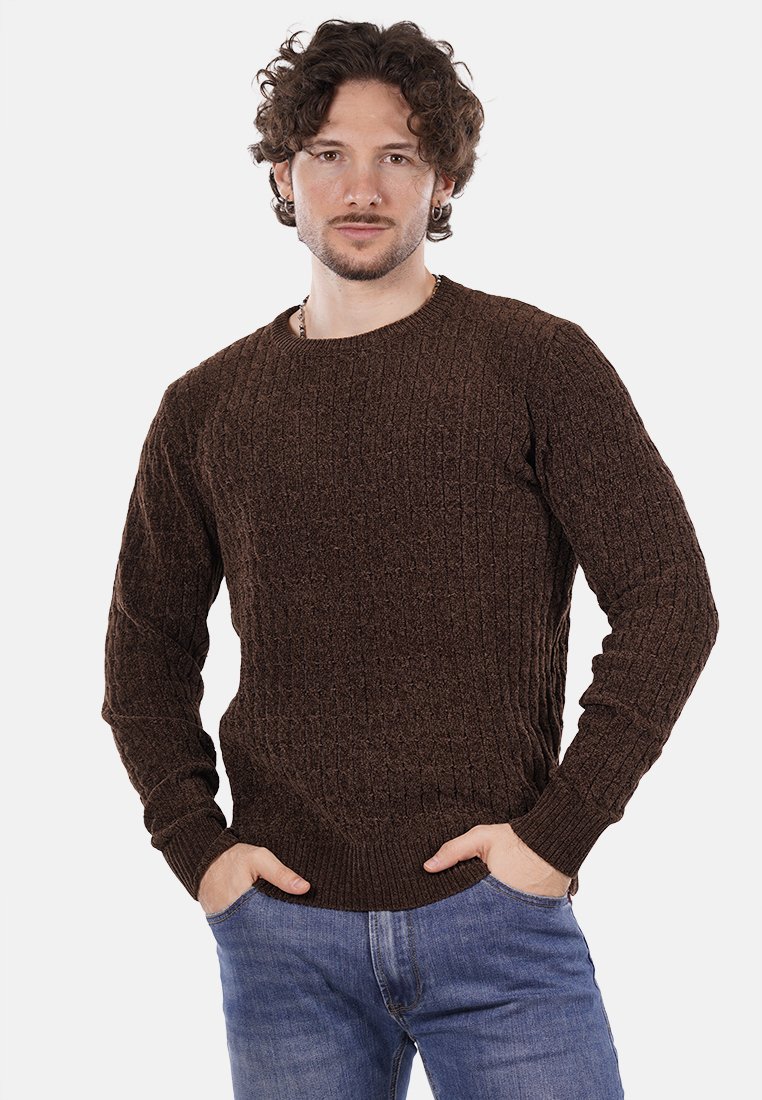 Maglione lavorato a maglia marrone con un motivo testurizzato, scollatura rotonda e polsini a costine, abbinato a jeans blu.