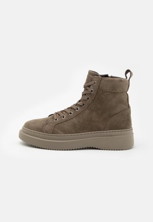 Brown suede high-top sneaker with thick sole, lace-up front, ankle padding, and pull tab on a white background.