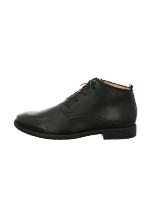 Schwarze Leder-Stiefeletten mit glatter Oberfläche, runder Zehenpartie und Schnürdesign. Flache Gummisohle und eine kleine dekorative Schlaufe auf der Rückseite.