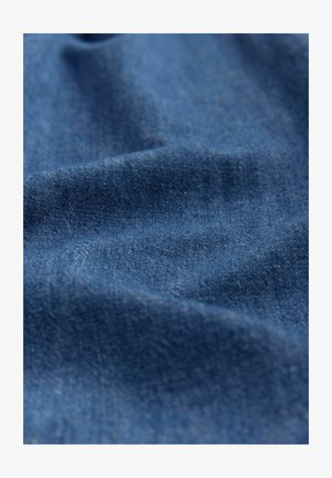 Denim-kangas, syvän sininen väri, sileä rakenne hienoilla vaihteluilla, hentoa kiiltoa ja pehmeää laskeutumista, esittelee satunnaisia kuituja ja kudontakuvioita.