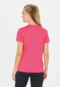 T-shirt med kort ärm i klarrosa, med rund halsringning och mjukt tyg. Baksidan har sömlösa sömmar och en figursydd design.