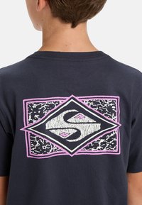 Navy cotton t-shirt with short sleeves, featuring a pink and black geometric logo design on the back. Soft texture with crew neckline.