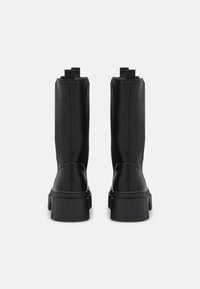 Black leather ankle boots with a sleek design, featuring a chunky sole, pull tabs, and vertical stitching on the sides.