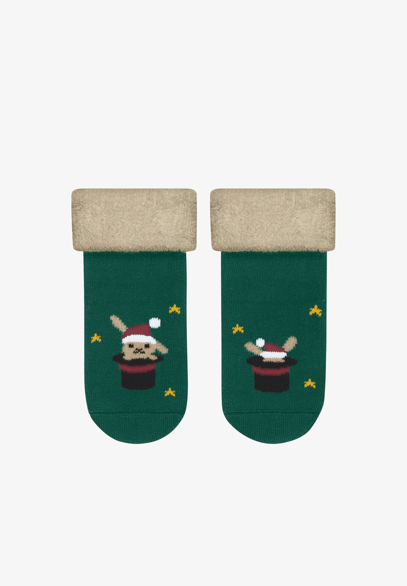 Grüne Socken mit einem flauschigen, beigen Saum. Das Design zeigt einen Cartoon-Hasen in einem Zauberhut, akzentuiert mit gelben Sternen.