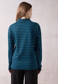 Langärmliges Poloshirt mit dunkelblauen und türkisfarbenen horizontalen Streifen, aus weichem Stoff mit Kragen und schmaler Passform.