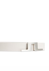 Vitt läderbälte med en slät yta, utrustat med en metallisk silverfärgad spänne med en geometrisk design och en unik ögla.