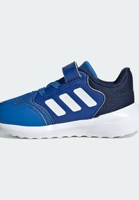 Niebieskie i granatowe sneakersy dla dzieci z białą podeszwą, trzema białymi paskami z boku, siateczkowym zapiętkiem, sznurowanym przodem oraz jednym paskiem na rzep.