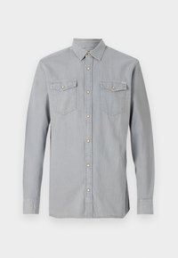 Camisa de mezclilla gris claro de manga larga con cuello abotonado, dos bolsillos en el pecho y botones dorados contrastantes. Textura suave y diseño clásico.