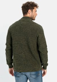 Olivgrüner Strickpullover mit strukturiertem Finish, geripptem Kragen und Bündchen. Er verfügt über eine lockere Passform und einen geraden Saum.