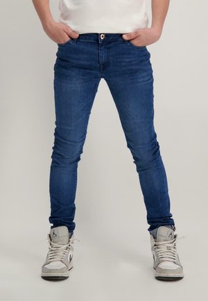 Blauwe denim skinny jeans met een klassiek ontwerp met vijf zakken en een subtiele wassing, gecombineerd met grijs-witte hoge sneakers.