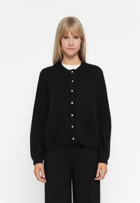 Cardigan en maille noire avec un motif texturé, col rond et boutons sur le devant. Manches longues avec poignets côtelés.