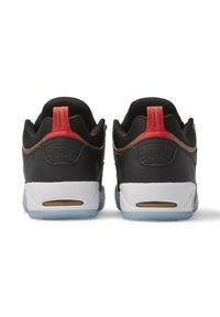 Black sneakers with a textured mesh upper, red and brown accents, white soles, and translucent blue outsole. DC logo visible on heel.