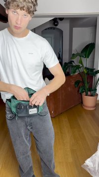 Bolsa de cintura de tela verde y negra con varios compartimentos, correa ajustable y logo de Columbia, llevada sobre unos jeans gris claro.